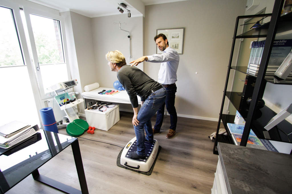 Traininingstherapie in einer orthopädischen Praxis mit Therapeut und Patientin auf dem Galileo Med 35